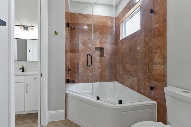 full bathroom featuring tile floors, vanity with extensive cabinet space, toilet, and enclosed tub / shower combo