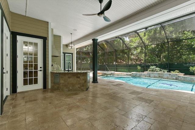 view of swimming pool with ceiling fan, pool water feature, a patio, glass enclosure, and sink