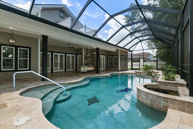 view of swimming pool with ceiling fan, a lanai, and a patio