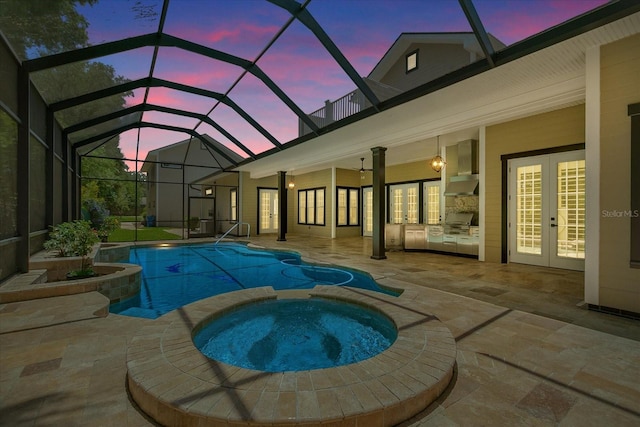 pool at dusk with a patio area, french doors, an in ground hot tub, and a lanai