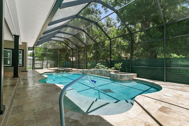 view of swimming pool featuring a patio, glass enclosure, and an in ground hot tub