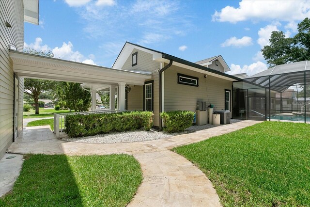 exterior space with a lanai and a lawn