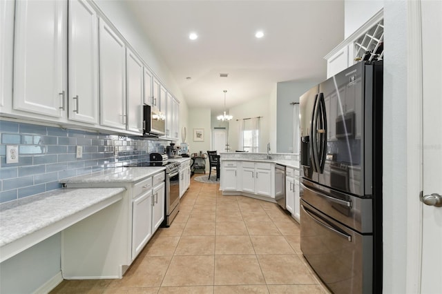 kitchen with appliances with stainless steel finishes, decorative light fixtures, sink, white cabinets, and light tile patterned floors