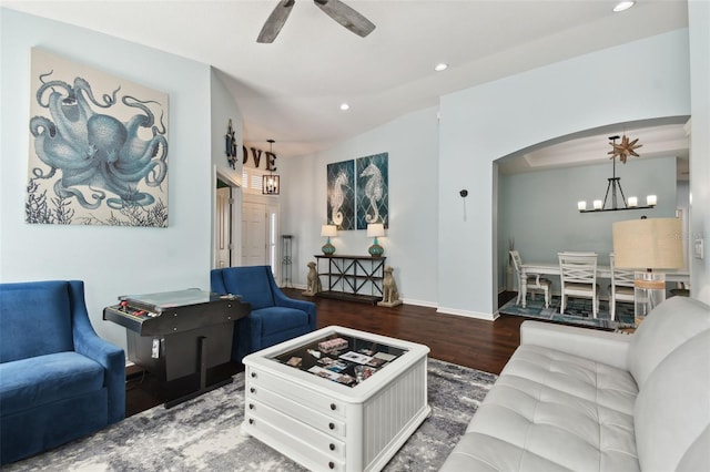 living room featuring lofted ceiling, dark hardwood / wood-style floors, and ceiling fan with notable chandelier