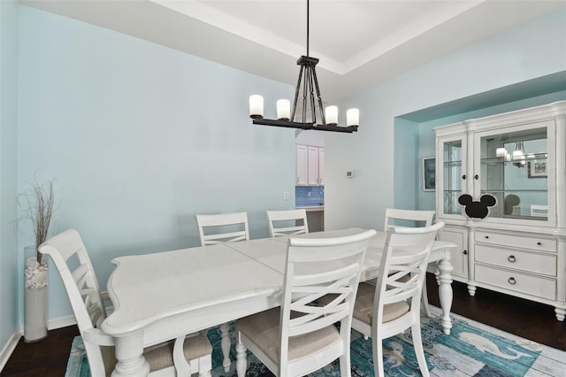 dining space featuring dark hardwood / wood-style floors and a chandelier