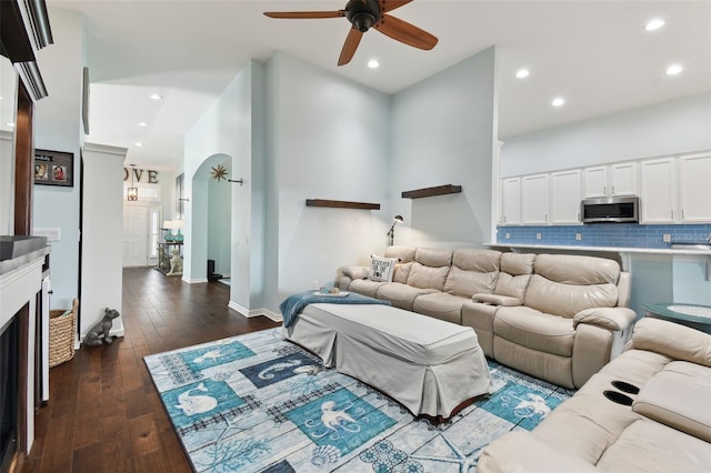 living room featuring ceiling fan and dark hardwood / wood-style flooring