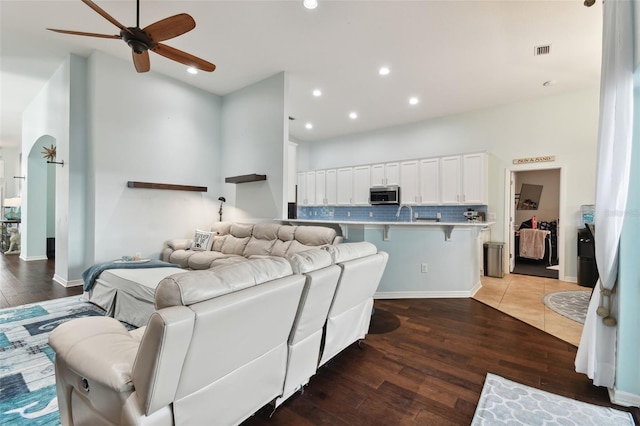 living room featuring ceiling fan and dark hardwood / wood-style flooring