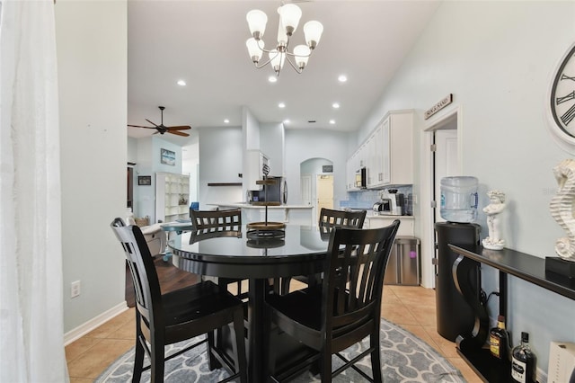 tiled dining space with ceiling fan with notable chandelier