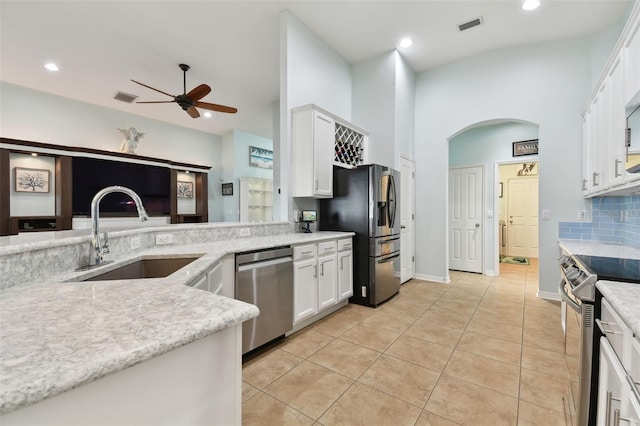 kitchen with sink, ceiling fan, appliances with stainless steel finishes, tasteful backsplash, and white cabinets