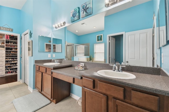 bathroom with walk in shower, vanity, and tile patterned flooring