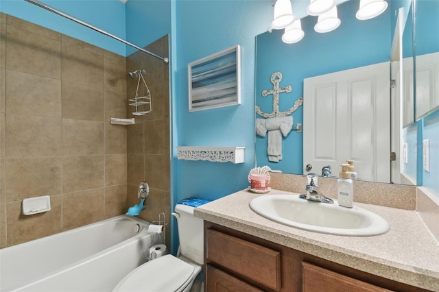 full bathroom with tiled shower / bath, vanity, and toilet