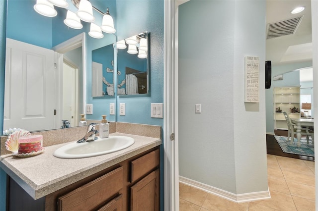 bathroom with vanity, a notable chandelier, and tile patterned floors