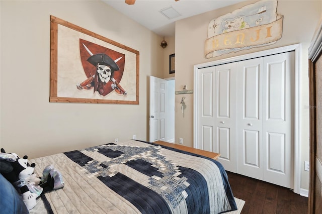 bedroom with dark hardwood / wood-style floors and a closet