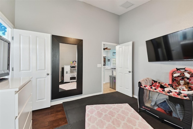 interior space with a towering ceiling and dark hardwood / wood-style floors