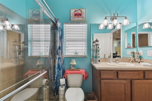 bathroom featuring vanity, toilet, and a shower with door