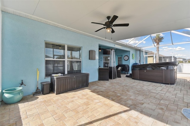 view of patio featuring a hot tub, a lanai, and ceiling fan