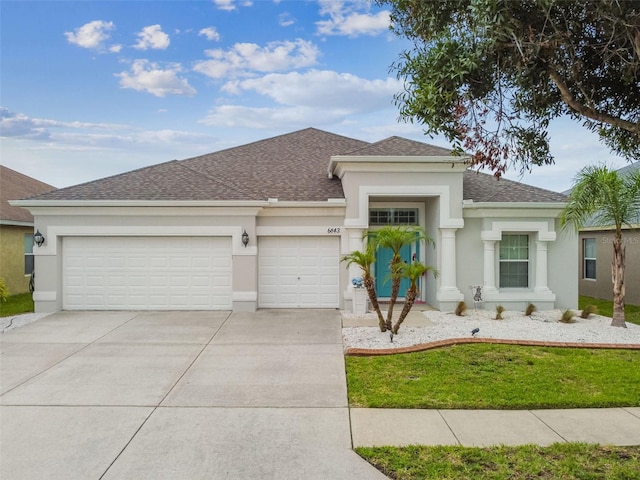 6843 Boulder Run Loop, Wesley Chapel, FL 33545 - view of front of house with an attached garage, concrete driveway, stucco siding, and a shingled roof
