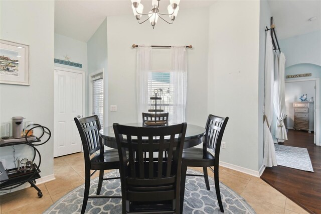 6843 Boulder Run Loop, Wesley Chapel, FL 33545 - dining area featuring light tile patterned floors, a chandelier, a towering ceiling, and baseboards