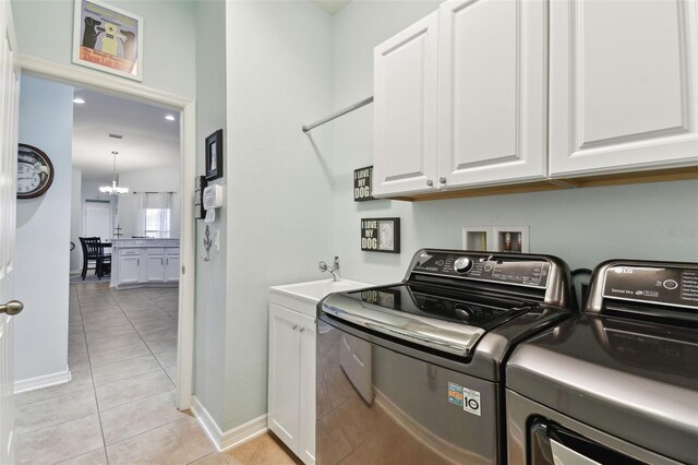 6843 Boulder Run Loop, Wesley Chapel, FL 33545 - laundry area featuring washing machine and clothes dryer, cabinet space, light tile patterned flooring, and baseboards