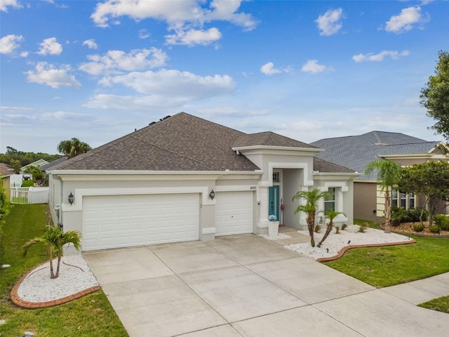 6843 Boulder Run Loop, Wesley Chapel, FL 33545 - view of front facade featuring a garage, roof with shingles, and stucco siding
