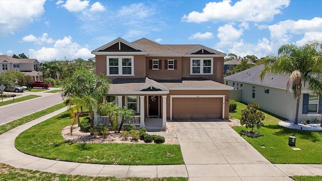 craftsman inspired home featuring covered porch, a garage, and a front yard