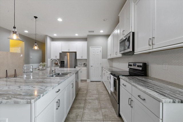 kitchen featuring appliances with stainless steel finishes, backsplash, sink, pendant lighting, and white cabinets