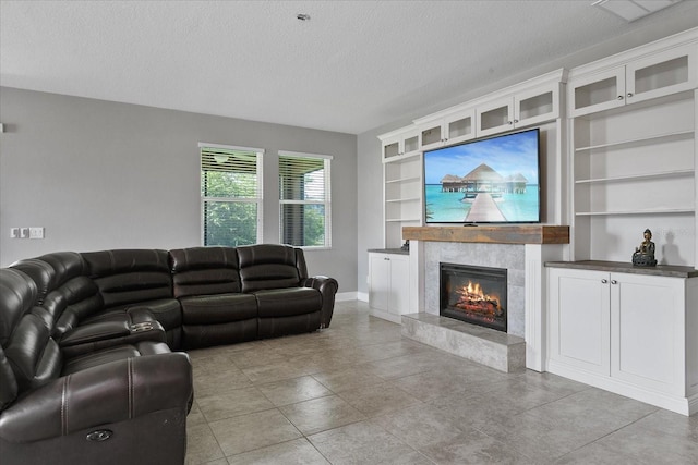 living room with built in features, a high end fireplace, and a textured ceiling