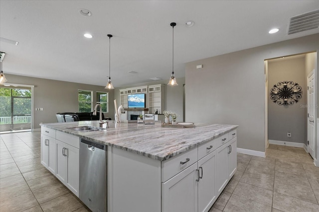 kitchen featuring white cabinets, light stone counters, a kitchen island with sink, sink, and dishwasher