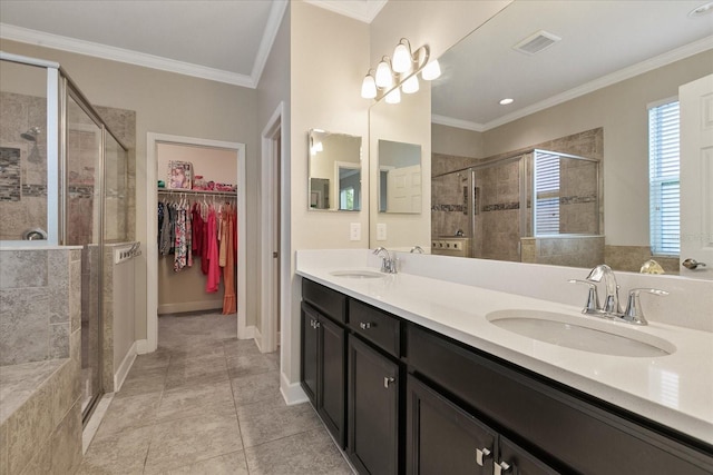 bathroom featuring tile patterned flooring, vanity, a shower with shower door, and ornamental molding