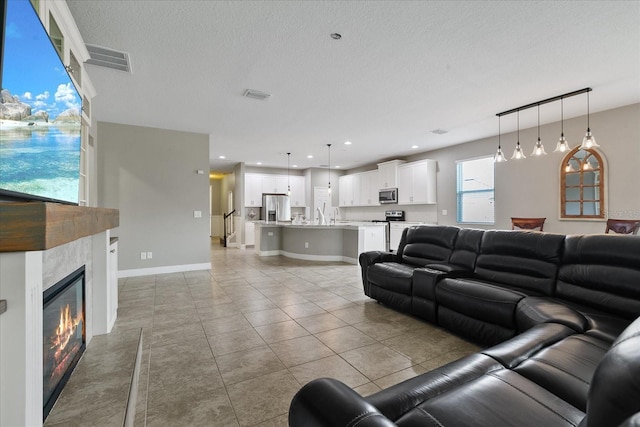 living room featuring a textured ceiling and light tile patterned flooring