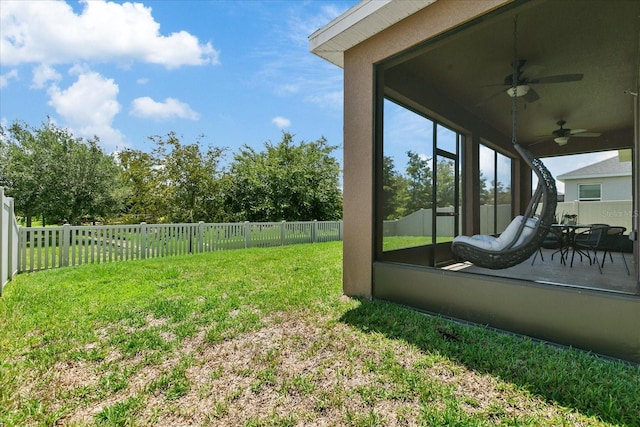 view of yard with a sunroom and ceiling fan