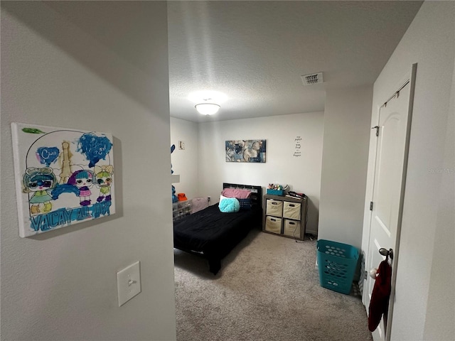 bedroom featuring light colored carpet and a textured ceiling