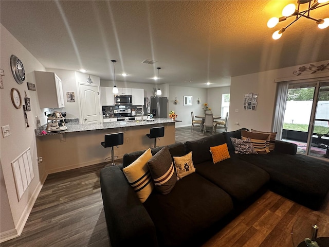 living room featuring dark hardwood / wood-style flooring, sink, and a chandelier