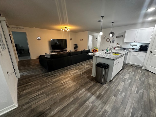 kitchen with sink, white cabinetry, dark hardwood / wood-style floors, light stone counters, and stainless steel dishwasher