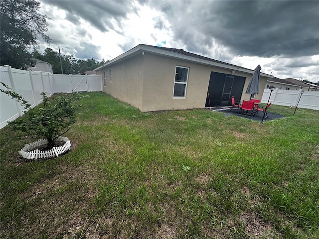 back of property with a lawn and a patio area