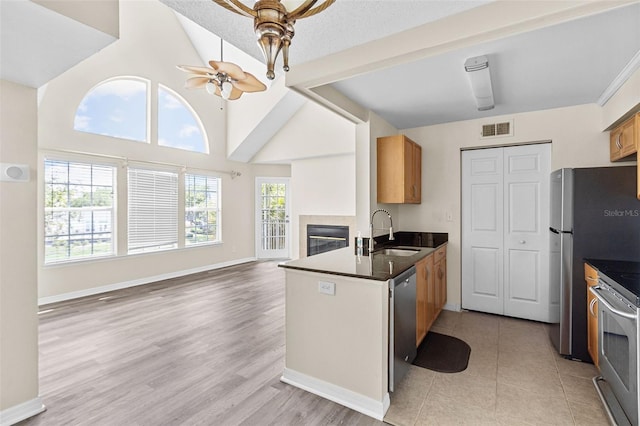 kitchen featuring appliances with stainless steel finishes, lofted ceiling, sink, kitchen peninsula, and ceiling fan