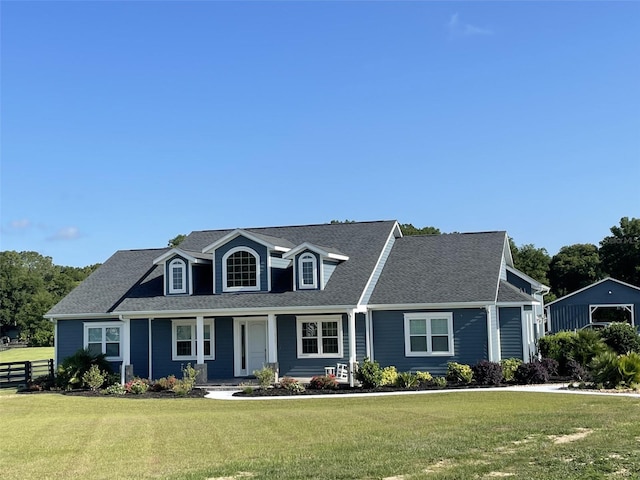 cape cod house featuring a front yard