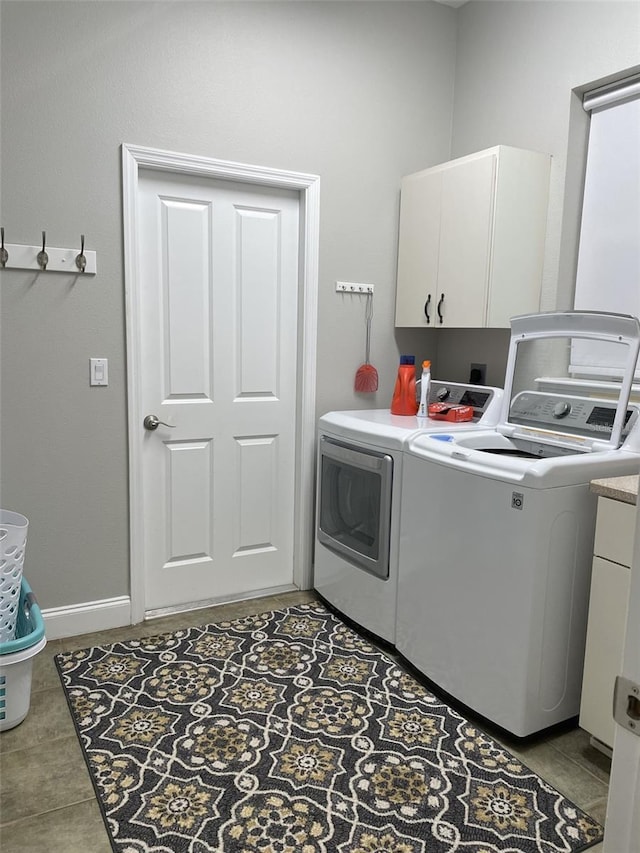 laundry room with light tile patterned floors, cabinets, and washing machine and clothes dryer