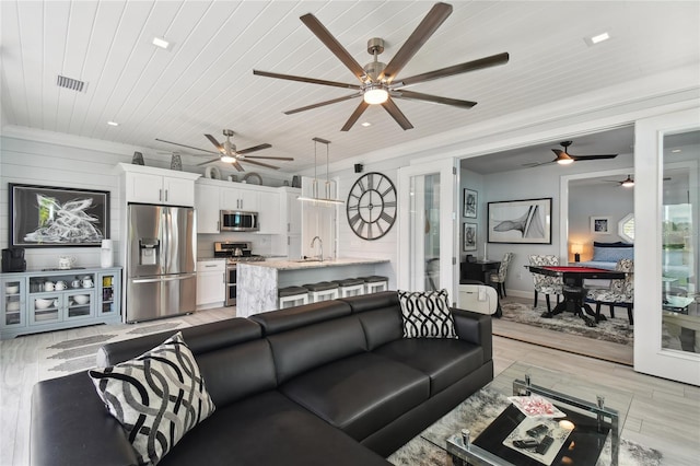 living room featuring wooden ceiling and sink