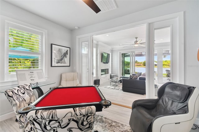 playroom with light wood-type flooring, ceiling fan, a healthy amount of sunlight, and billiards