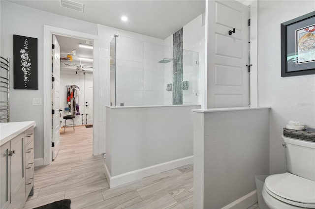 bathroom featuring toilet, vanity, and walk in shower