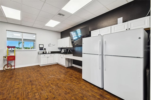 kitchen with a paneled ceiling, white fridge, and white cabinetry