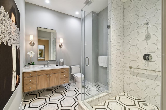 bathroom featuring vanity, toilet, and a shower with door