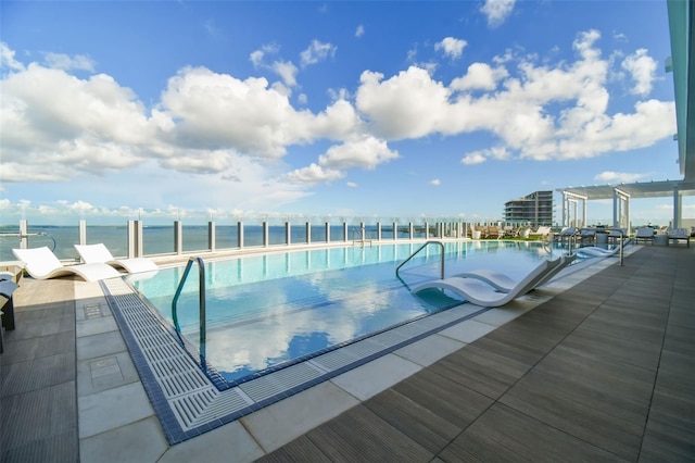 view of pool featuring a patio area and a water view