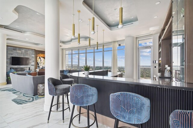 bar featuring a raised ceiling and a fireplace