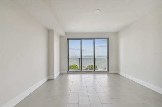 unfurnished room featuring a water view