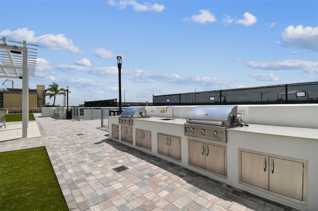 view of patio / terrace featuring a pergola, area for grilling, and sink