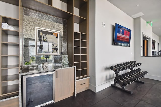 bar with stone countertops and beverage cooler