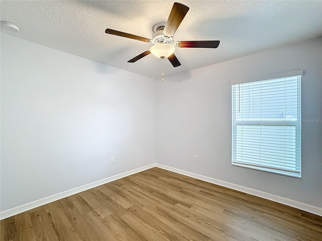 spare room with a textured ceiling, light hardwood / wood-style floors, and ceiling fan