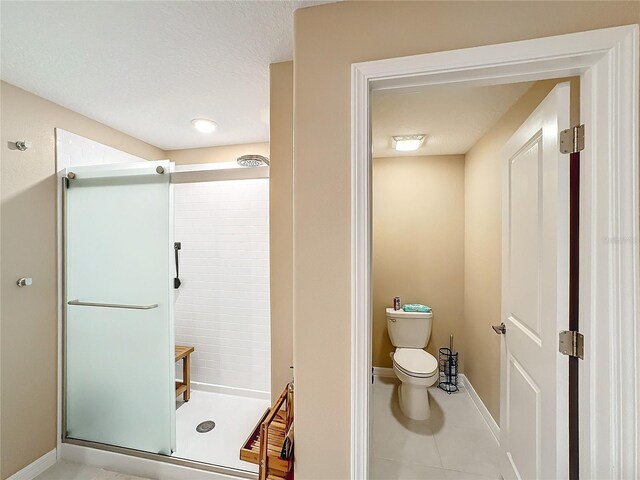 bathroom featuring walk in shower, tile patterned flooring, and toilet